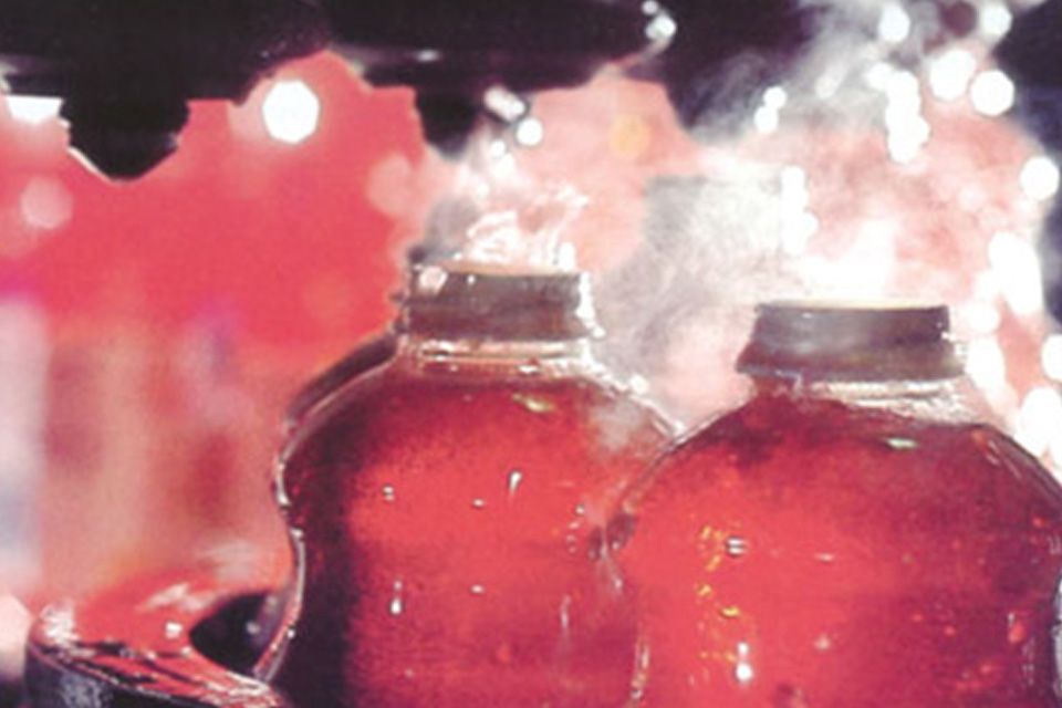 Bottles being filled on a conveyor belt in a manufacturing unit