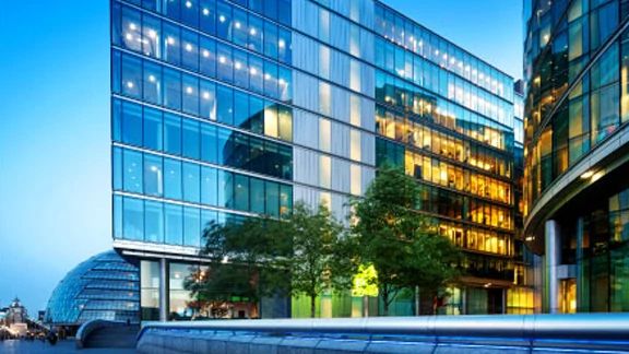 Exterior of two corporate buildings with glass windows, surrounded by trees