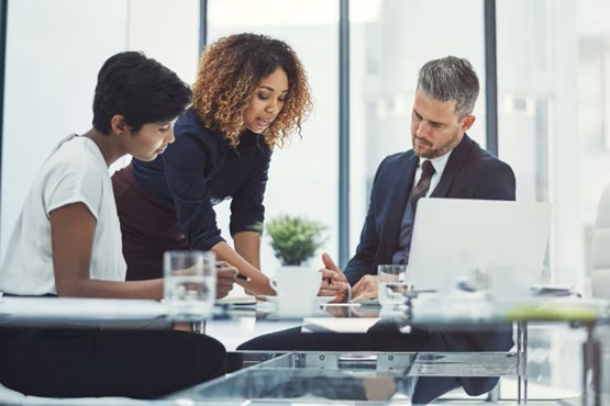 Three colleagues- in discussion at an office desk-thumbnail