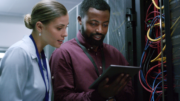 Two engineers- inspecting a server rack