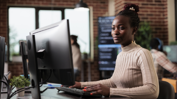A woman working -on a desktop -sitting at a work stationpage list