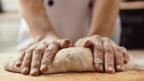 A baker kneading dough