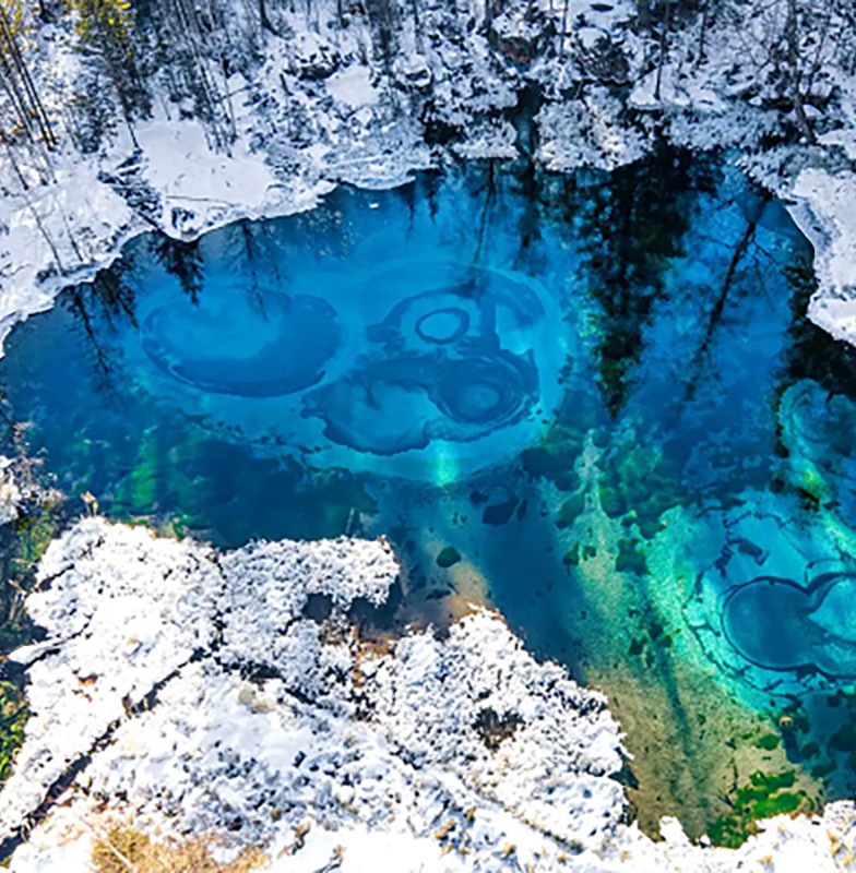 A clear water lake within a forest during the winter