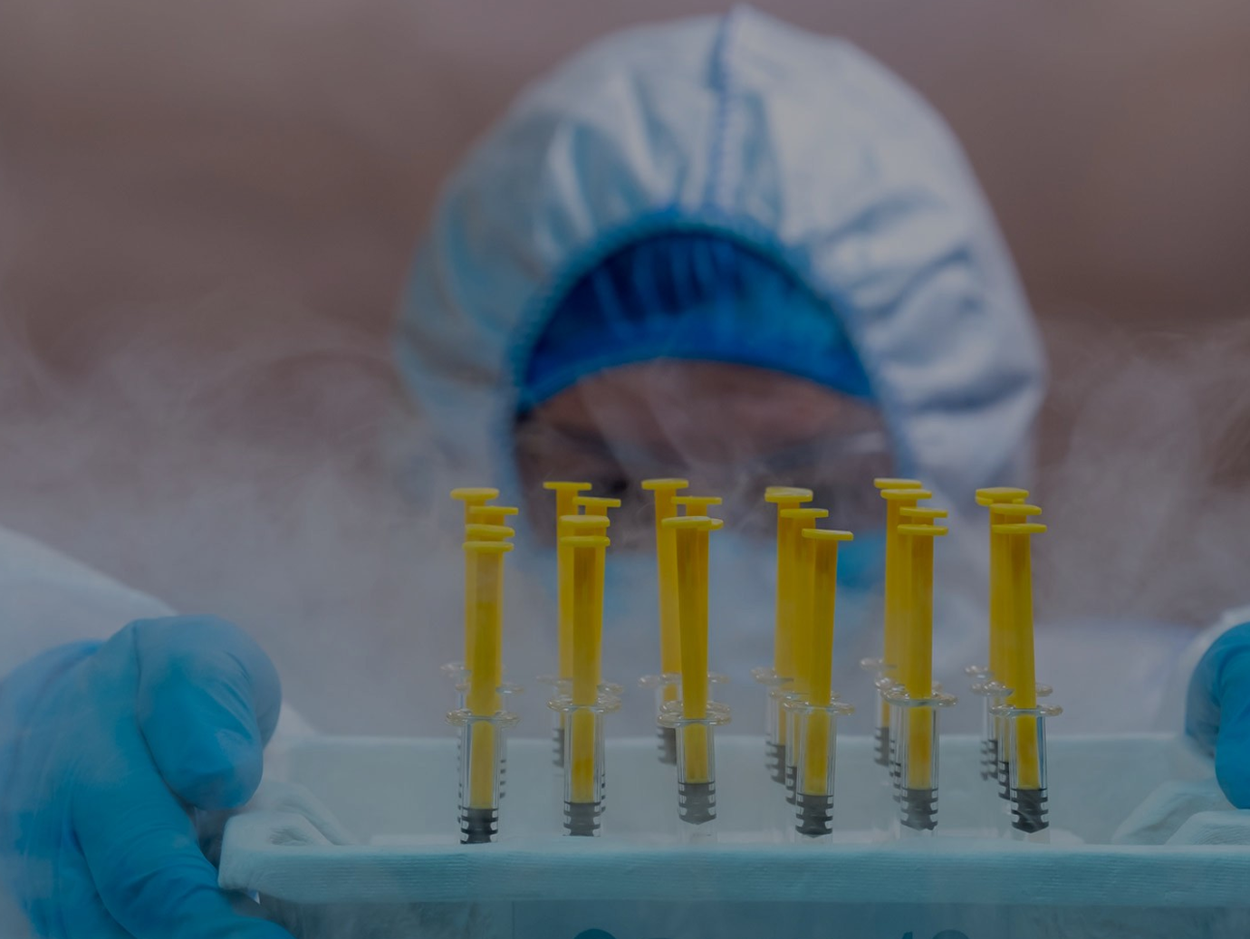 Medical staff holding a COVID-19 vaccine tray inside a freezer
