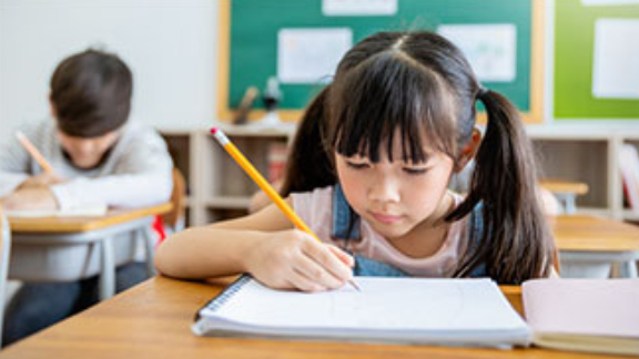 Girl with two ponytails writing in a notebook