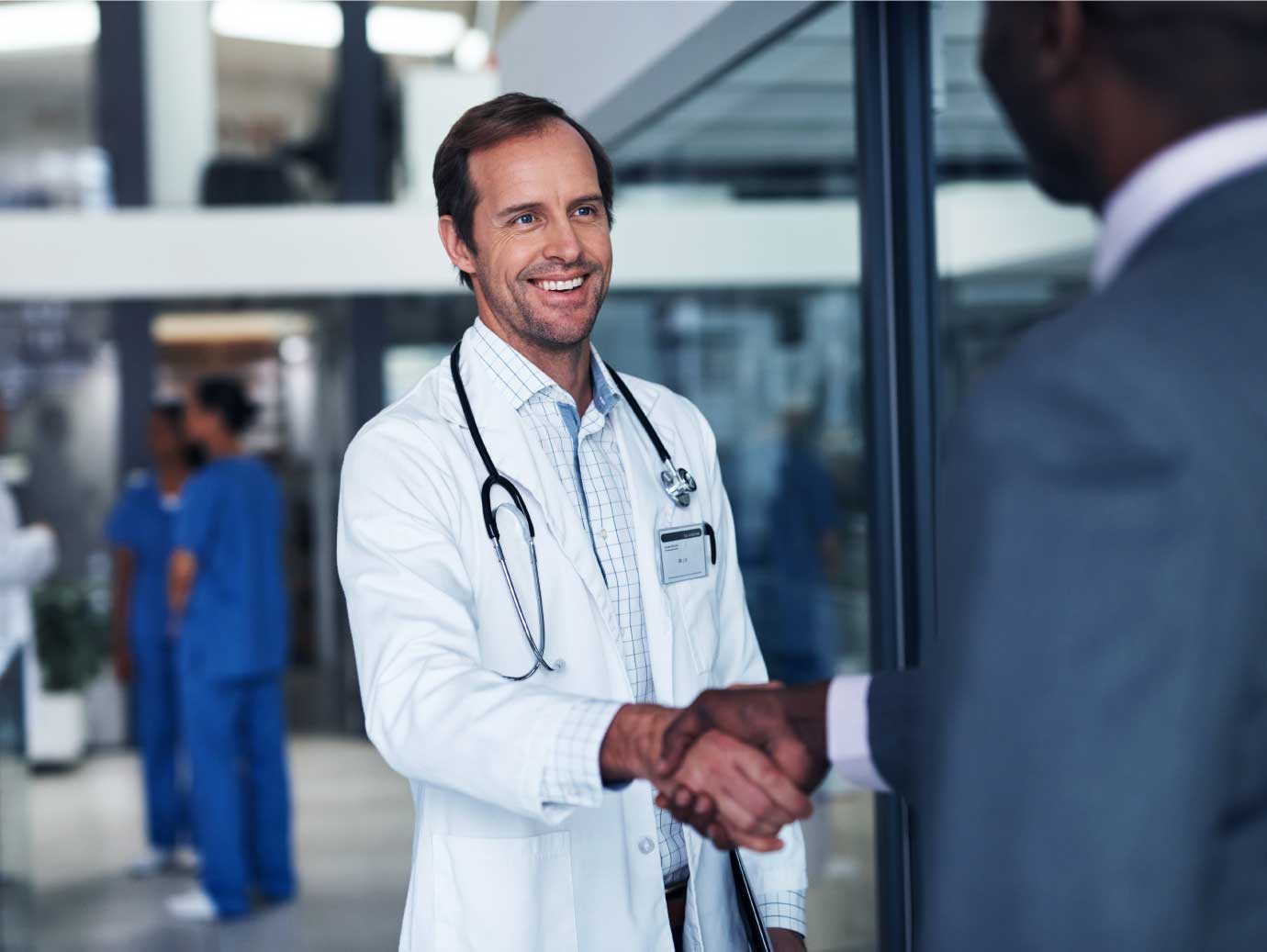 Male doctor handshaking with other person