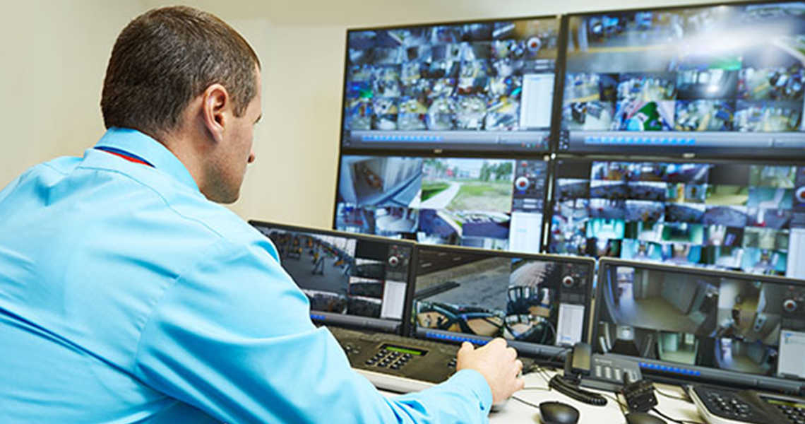A security guard watching surveillance footage on a monitor