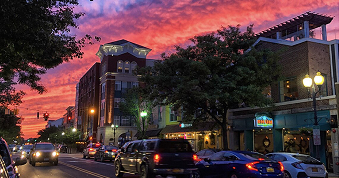 A busy street lined with shops at the Village of Patchogue