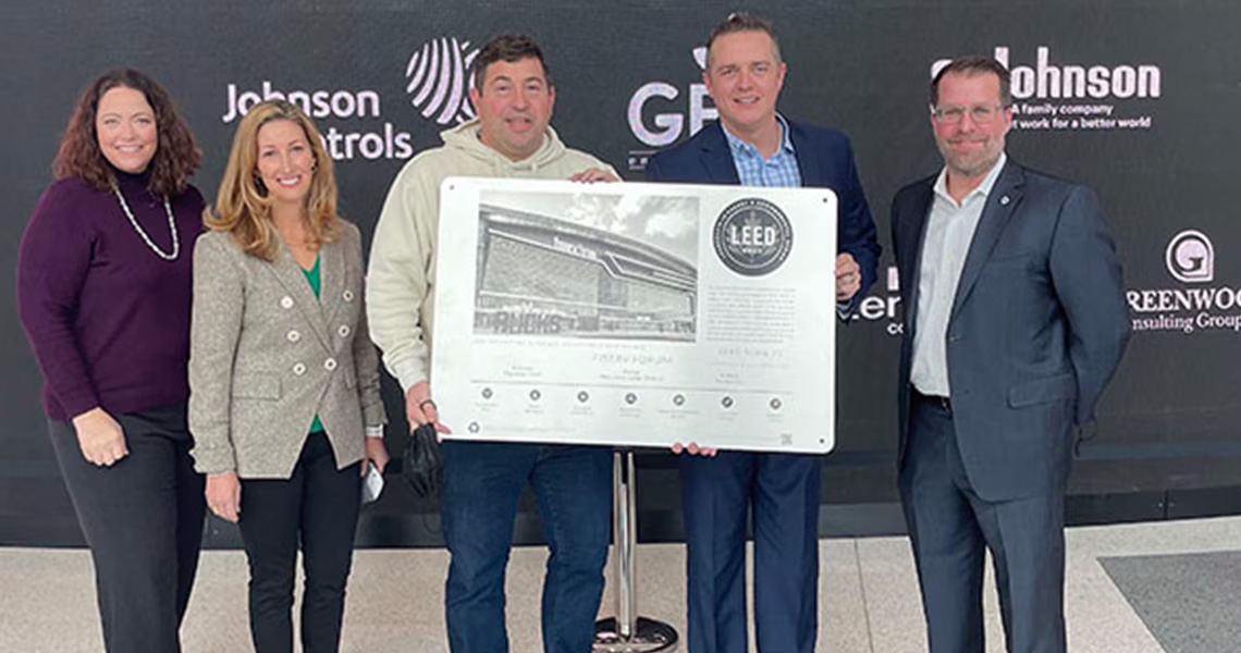 A group of people posing for a photograph with the LEED® Gold Certificate