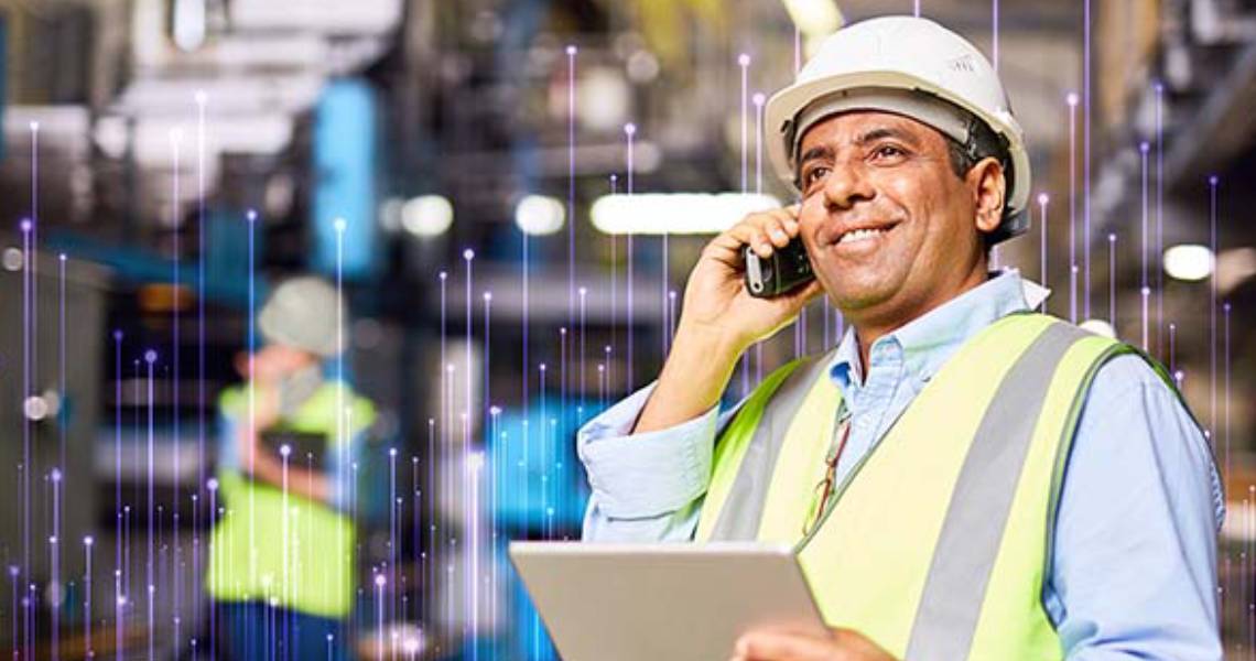 Maintenance worker holding a writing pad while talking on a mobile phone