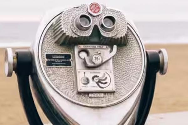 A pair of binoculaurs on a stand at a beach
