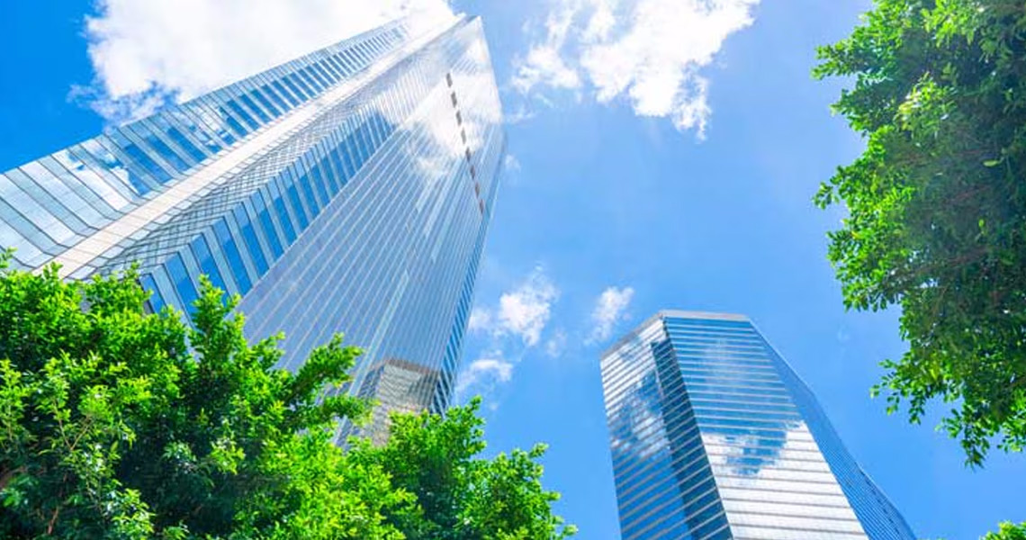 Low-angle view of high-rise buildings surrounded by greenery