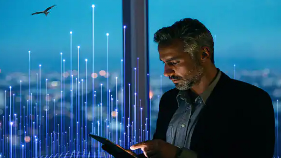 Man using a tablet near a window overlooking the city, overlaid with a graphic of transmission nodes