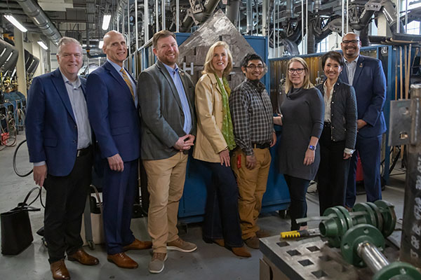 Leaders from Johnson Controls, government and the local community smile with HACC student Paul Arciba during a tour of the HACC training facility.