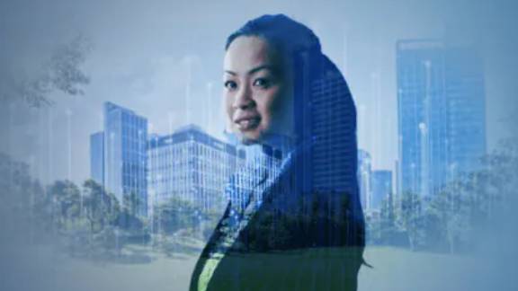 A businesswoman smiling, with buildings in the background