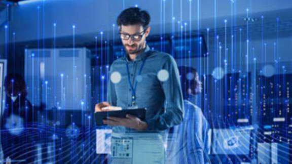 A male employee using a tablet, overlaid with a graphic of transmission nodes