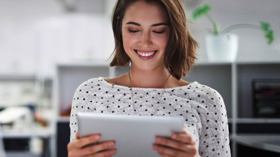 Woman smiling while using a tablet