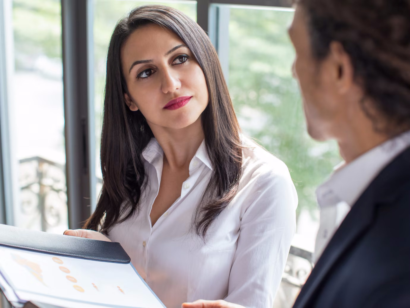 Two colleagues in conversation holding a file