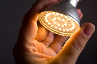 Close-up of a person's hand adjusting a study lamp