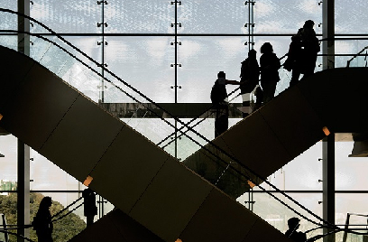 Silhouette of people on escalators inside a building