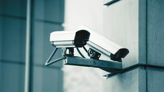two video surveillance cameras on the exteriors of a building