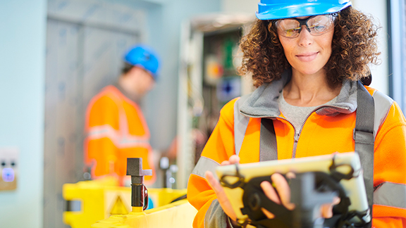 A female maintenance engineer looking a tablet