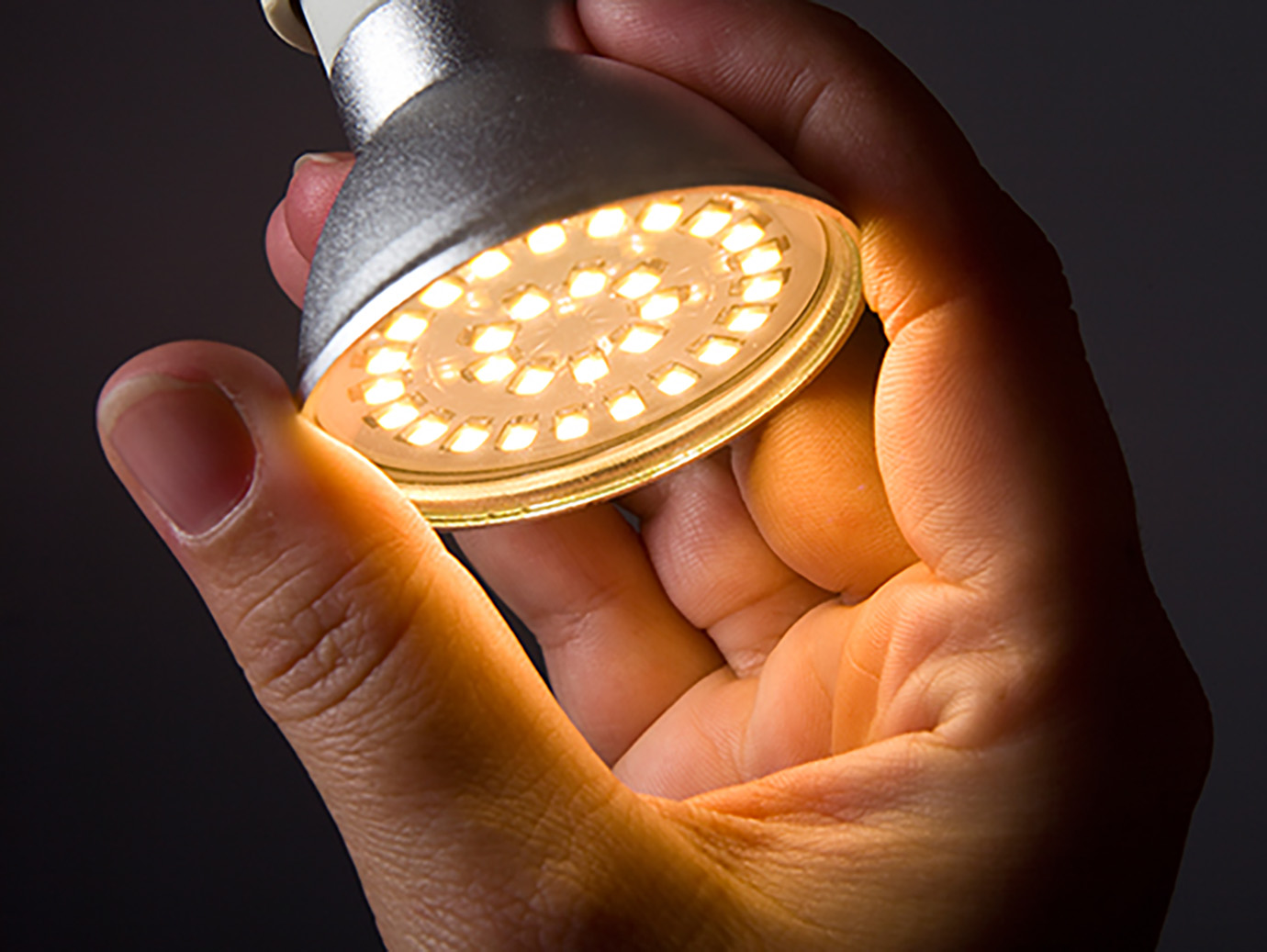 Close-up of a person fixing an electric bulb