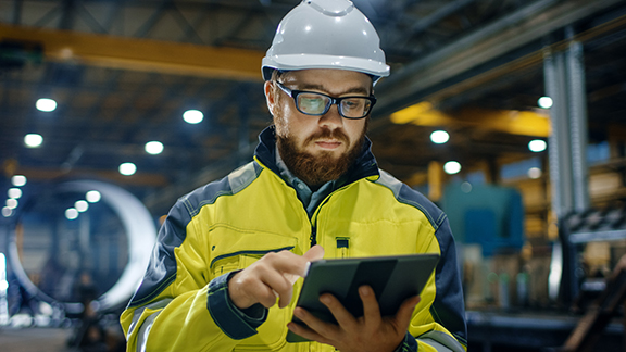 A maintenance engineer scrolling on a tablet