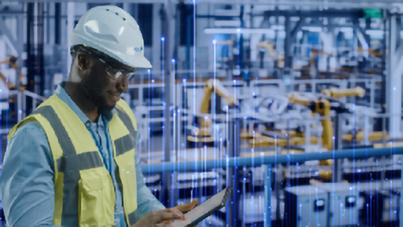 A maintenance worker scrolling on a tablet, with OpenBlue graphics in the background
