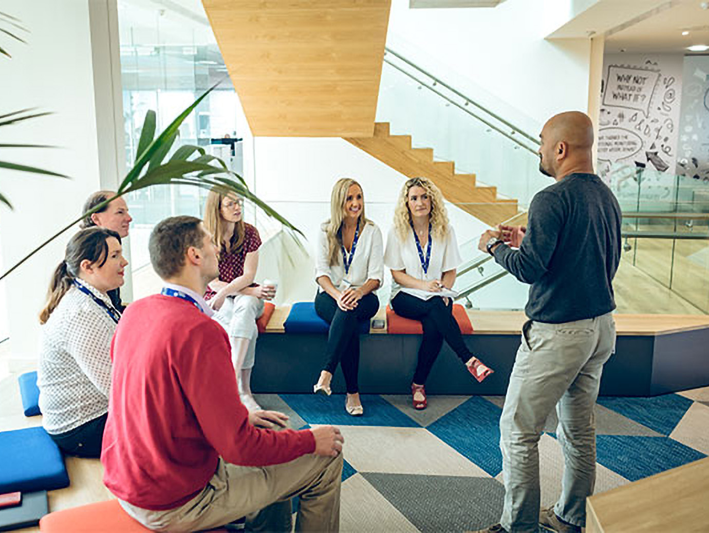 Man standing and speaking in front of a group of people