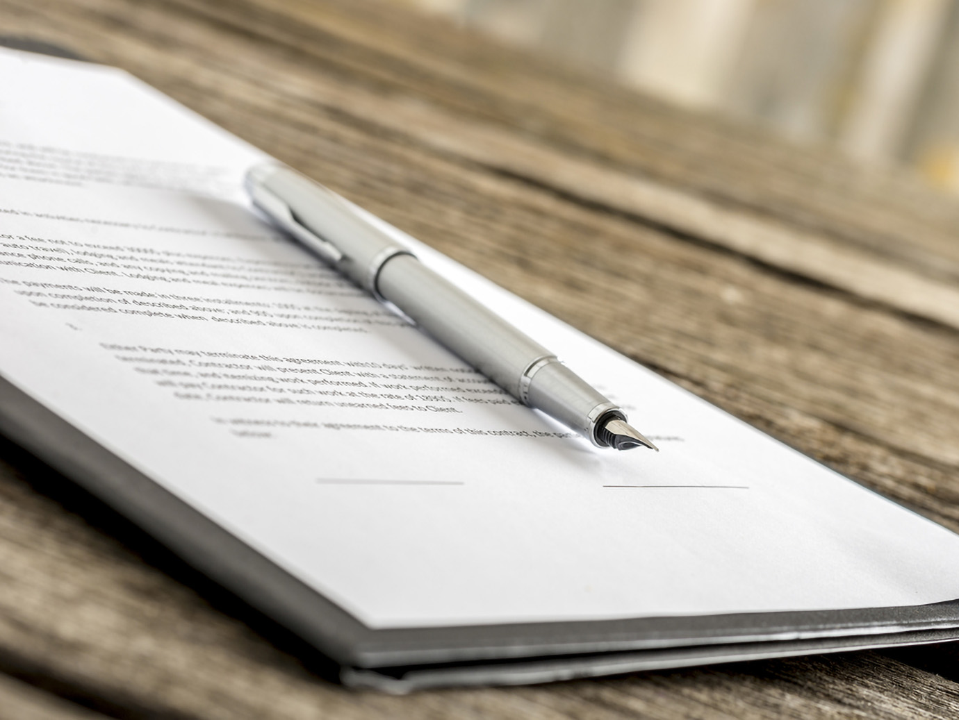A fountain pen on a stack of documents on a table